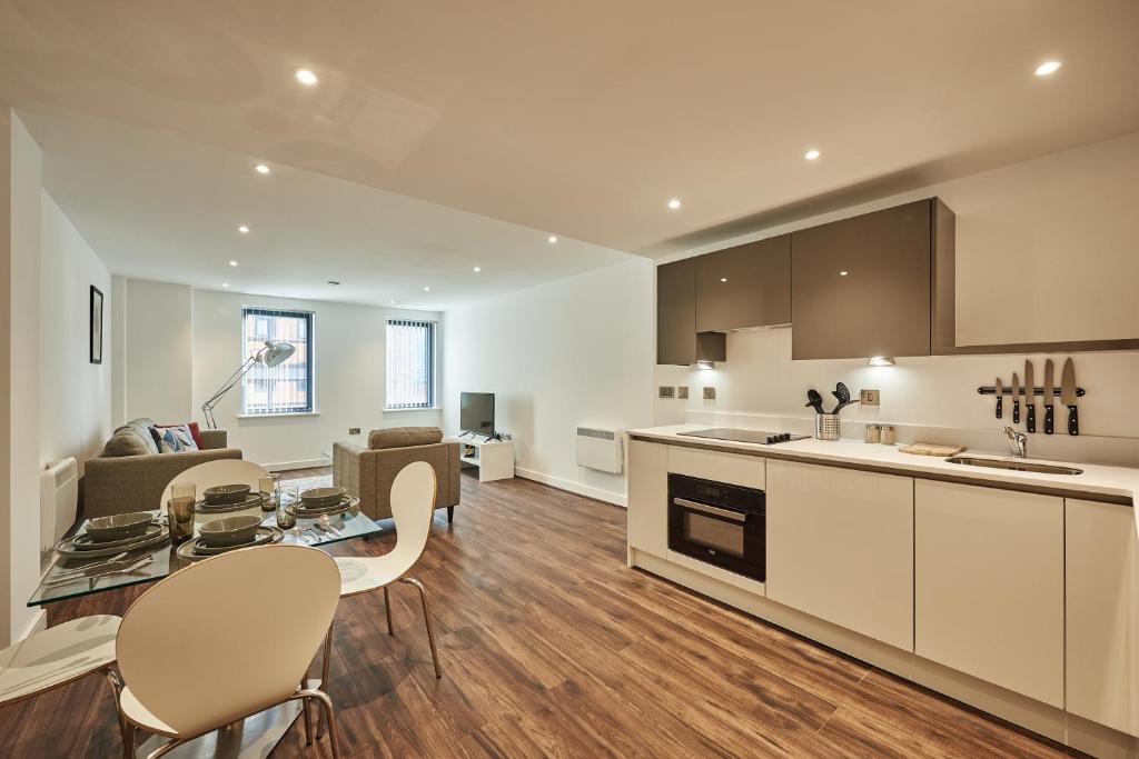 a kitchen and living room with a table and chairs at Seven Living Jewellery Quarter in Birmingham