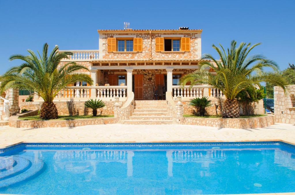 a villa with a swimming pool in front of a house at Finca Cullera in Calonge