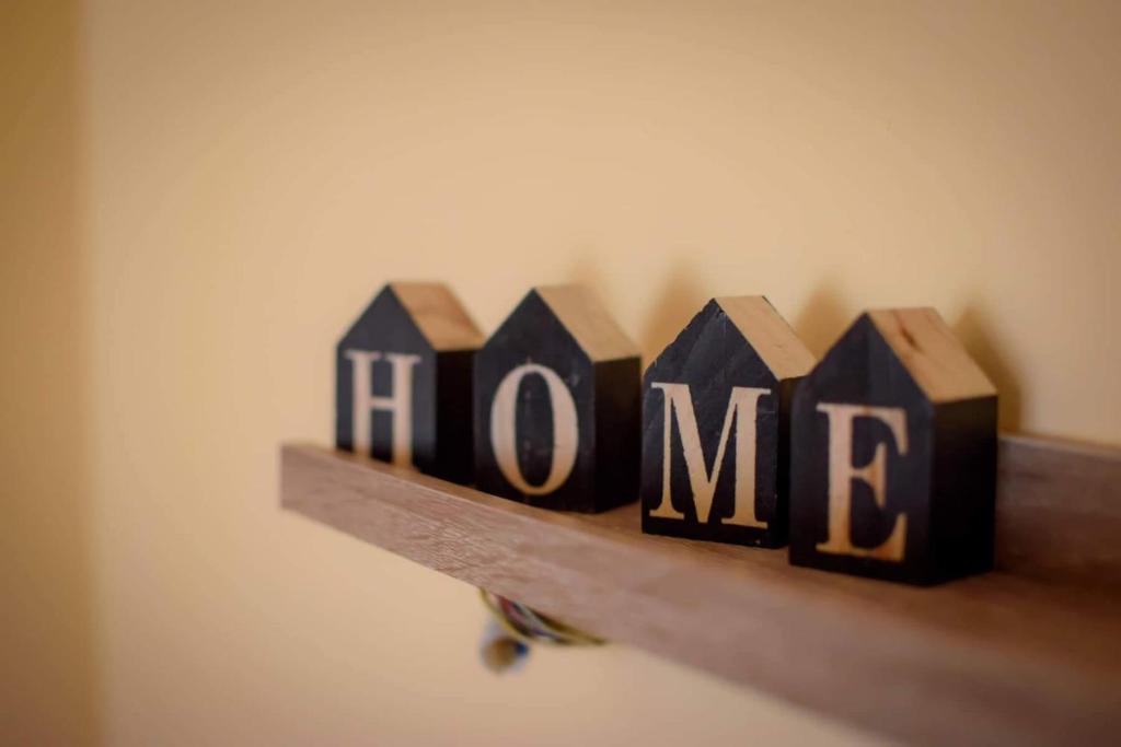 a wooden block with the word home on a shelf at HOME in Patra