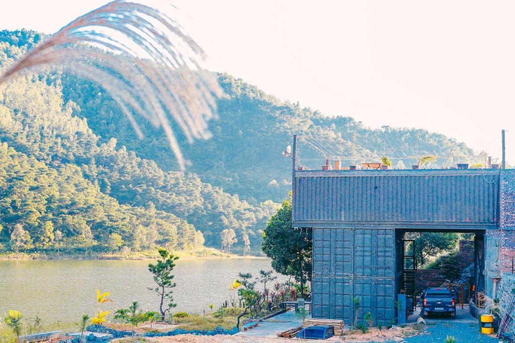 a building next to a river with a mountain at GISY Lake House 1F in Hanoi