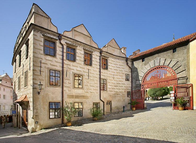 duży kamienny budynek z dużymi łukowymi drzwiami w obiekcie Pension Zámecká Apartmá - Castle Apartments w Czeskim Krumlovie