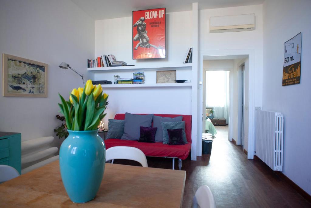 eine blaue Vase auf einem Tisch im Wohnzimmer in der Unterkunft Morimondo House: fashion & design in Mailand