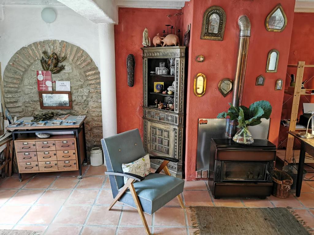 Habitación con paredes rojas, silla y escritorio. en Hostel Argonauta en Óbidos