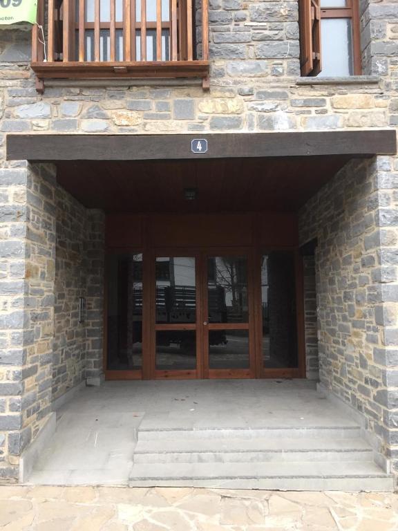 an entrance to a stone building with wooden doors at TU APARTAMENTO EN EL VALLE DE TENA en ESCARRILLA in Escarrilla