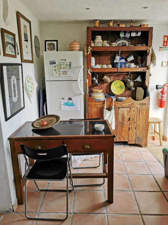 a kitchen with a wooden table and a refrigerator at Hostel Argonauta in Óbidos