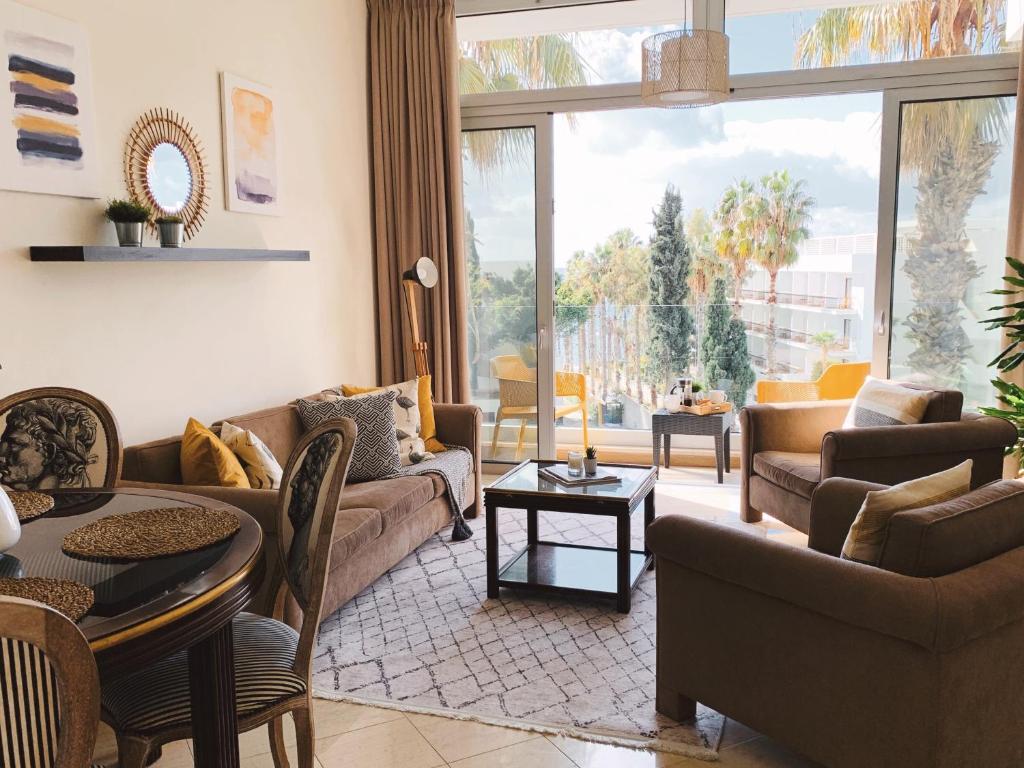 a living room with furniture and a large window at Poseidon's Luxury Apartment in Paphos