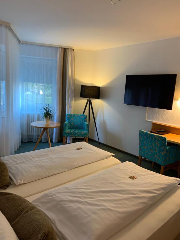 a hotel room with two beds and a tv at Hotel Schober in Freiberg am Neckar