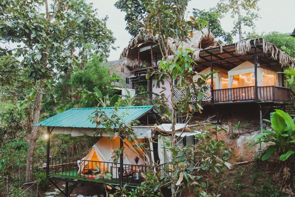 una casa en la selva con un techo azul en Baansuan Chomchun en Amphoe Mae Taeng