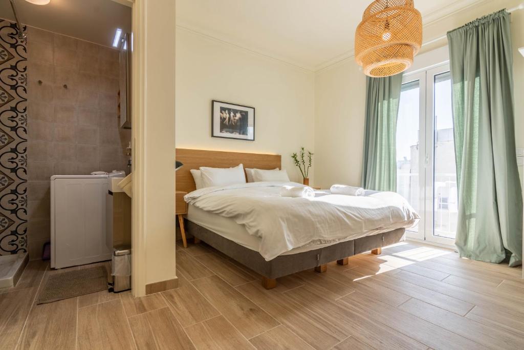 ein Schlafzimmer mit einem Bett und einem großen Fenster in der Unterkunft Birds Nest in Athen