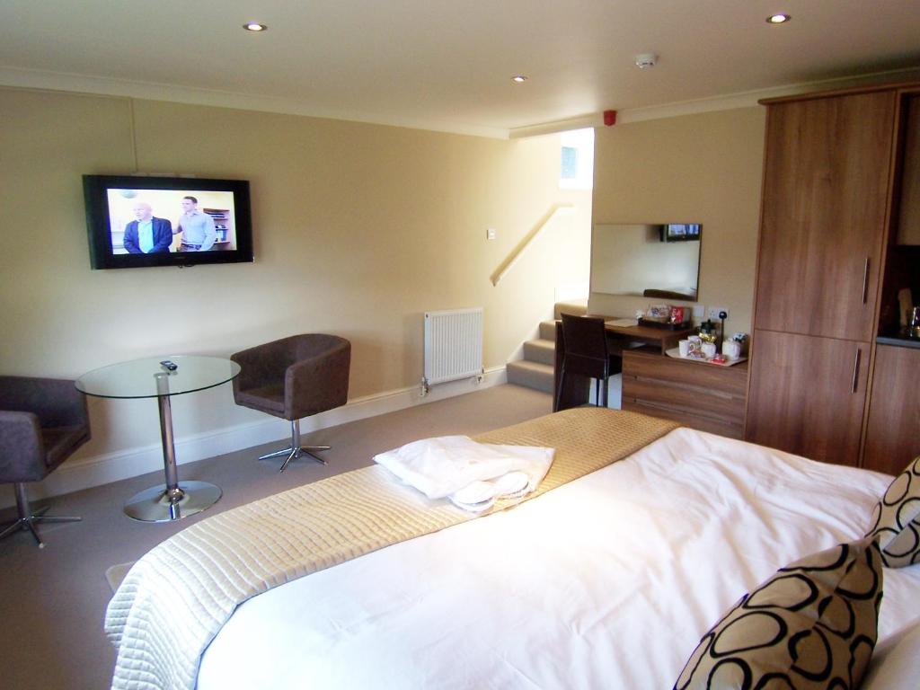 um quarto com uma cama e uma televisão na parede em Bagshaw Lodge em Bakewell