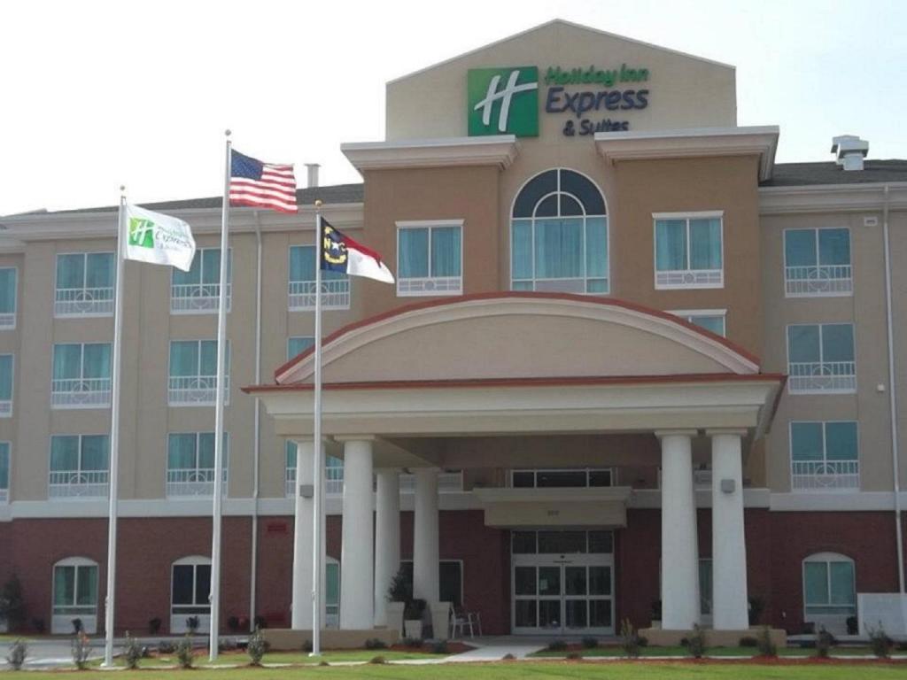 an office building with two flags in front of it at Holiday Inn Express & Suites - Smithfield/Selma, an IHG Hotel in Smithfield