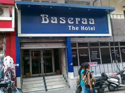una donna che cammina davanti a un bacco l'hotel di Baseraa Hotel a Rishikesh