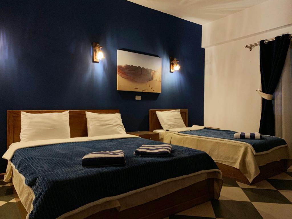 ダハブにあるSea Soul Hotelのベッドルーム1室(ベッド2台付)が備わります。壁には絵画が飾られています。