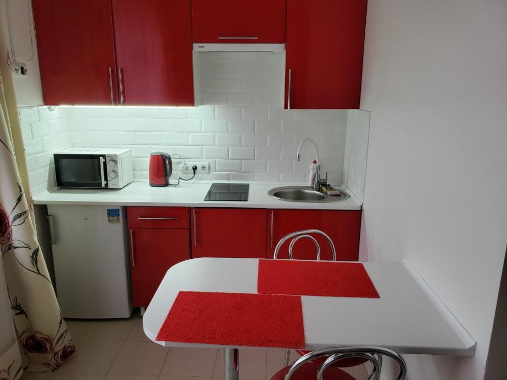 una pequeña cocina con armarios rojos y fregadero en Апартаменти Сонячне, en Polyana