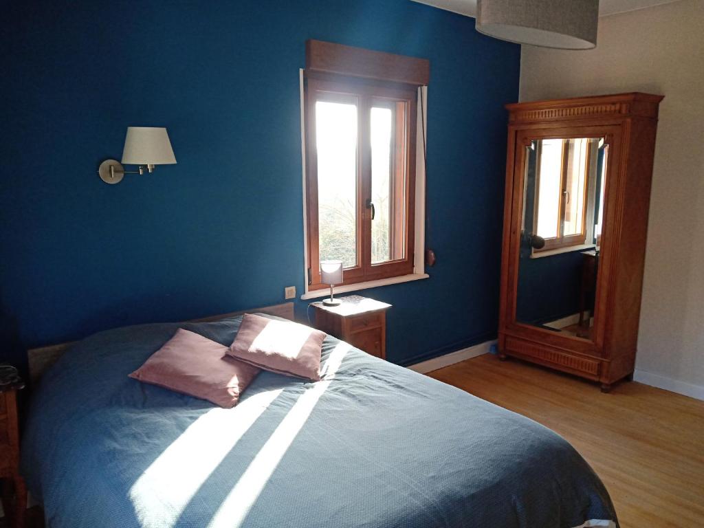 Dormitorio azul con cama y ventana en Chambre double dans Auberge Alsacienne, en Scherwiller