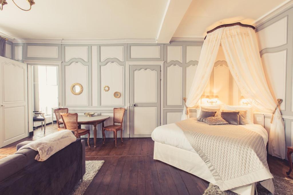 - une chambre avec un lit, une table et des chaises dans l'établissement La Maison de la Liberté Suite Jeanne Barret, à Poitiers