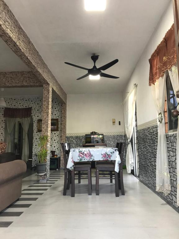 d'une salle à manger avec une table et un ventilateur de plafond. dans l'établissement cozy and calm place to stay, à Kajang