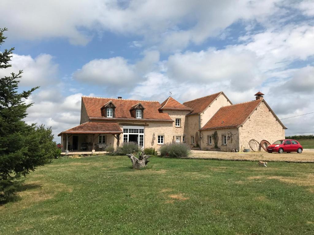 a large house with a red car parked in front of it at Chez sandrine in Mouhet