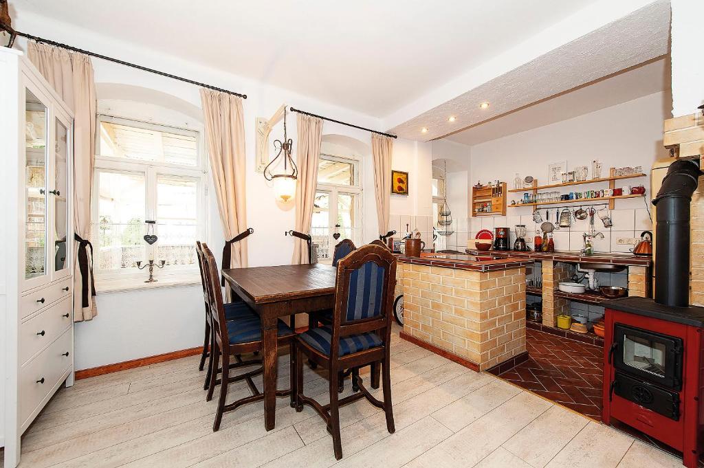 Dohna的住宿－Ferienwohnung Gans Auguste，厨房配有木桌和壁炉。