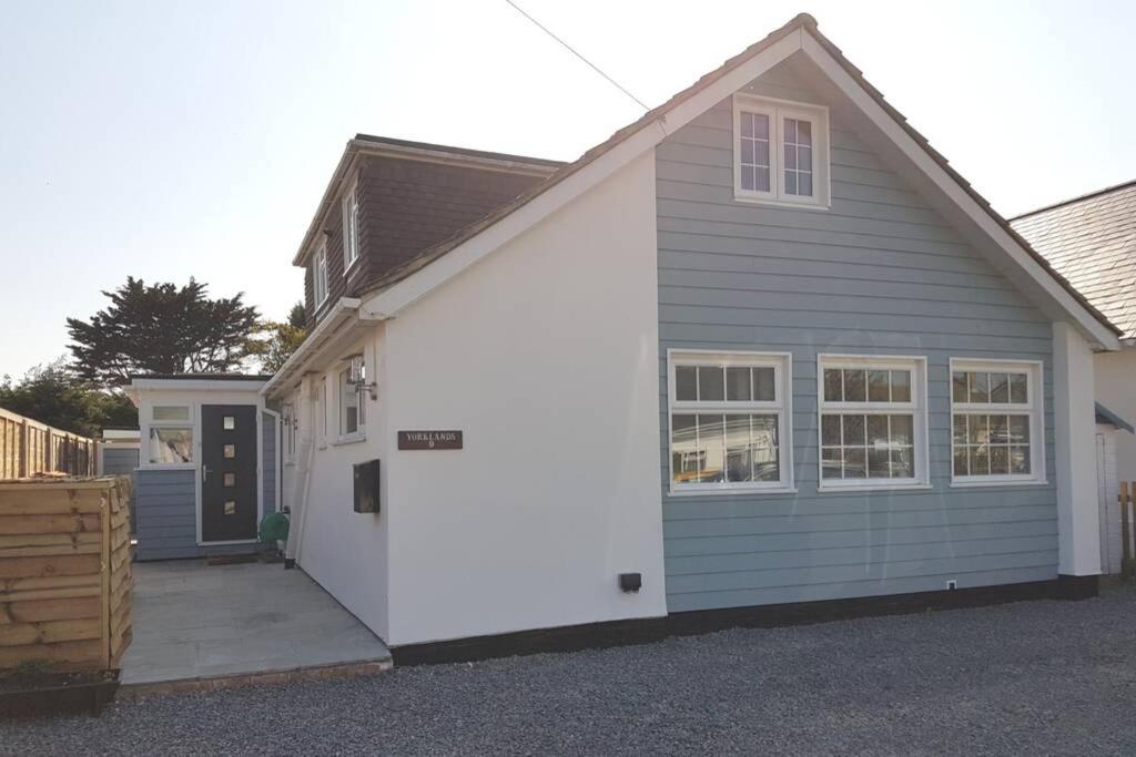 a gray and white garage with a driveway at The Garden Room in Chichester
