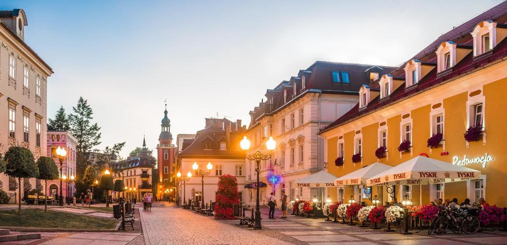 una calle de la ciudad con edificios y gente caminando por la calle en Hotel Restauracja Caspar, en Jelenia Góra