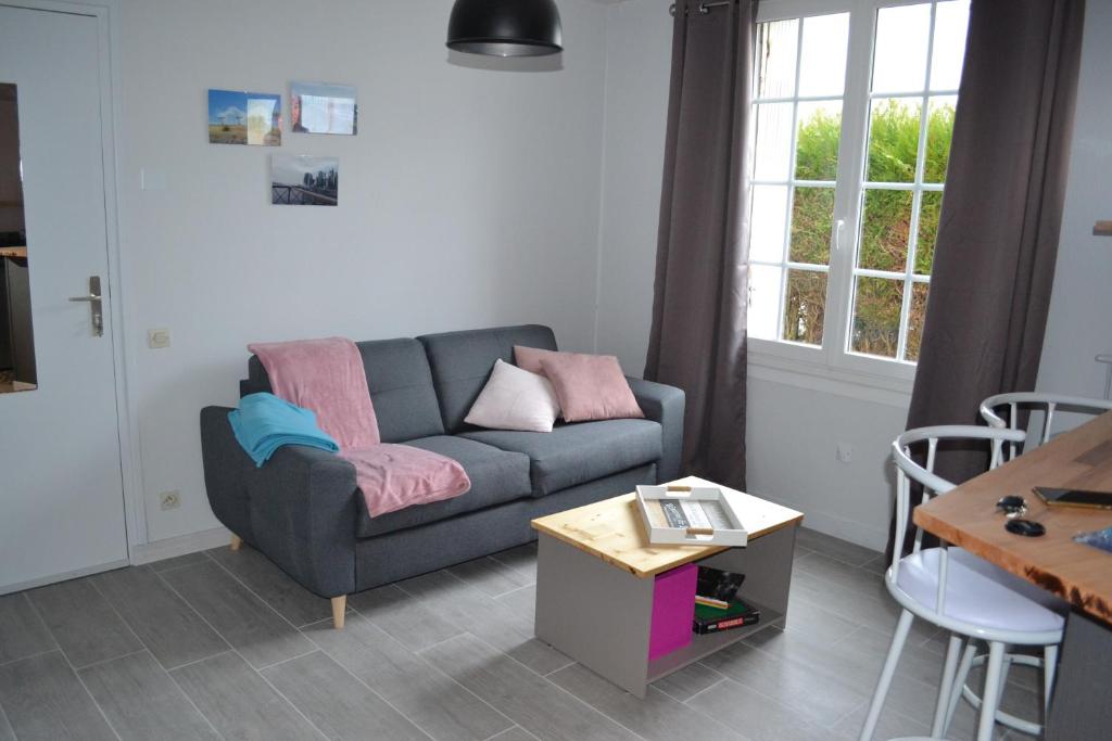 a living room with a couch and a table at Jolie T2 au coeur du bourg in Carnac