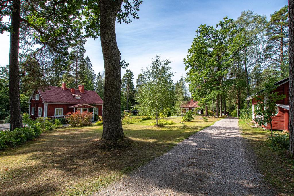 un vialetto che conduce a una casa rossa e a un albero di Villa Tammikko a Tuusula