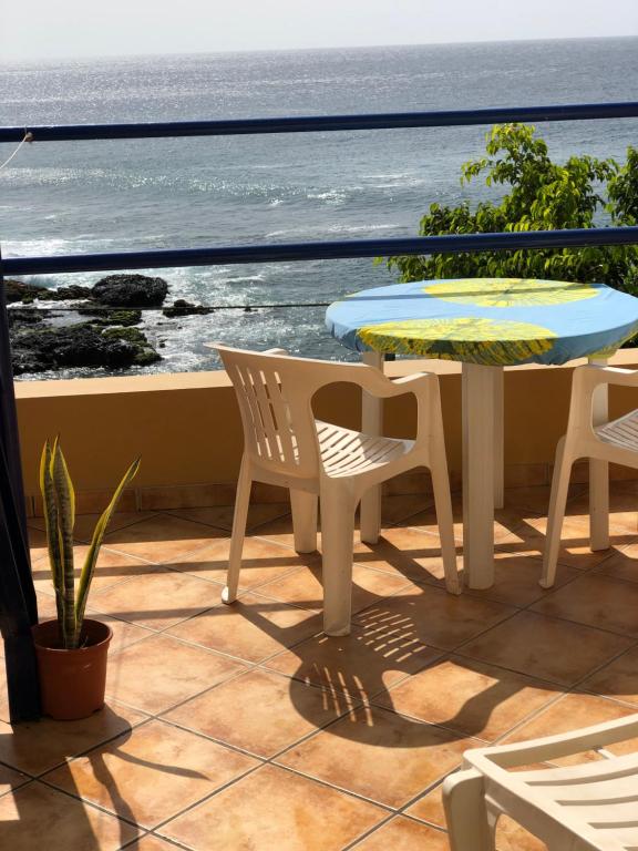 eine Terrasse mit einem Tisch, Stühlen und Meerblick in der Unterkunft Splendid Guest Suite with Separate Private Ocean View Terrace in Praia
