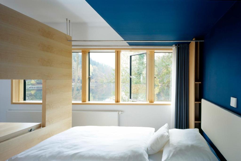 a bedroom with a bed and a blue wall at seehaus forelle haeckenhaus in Ramsen