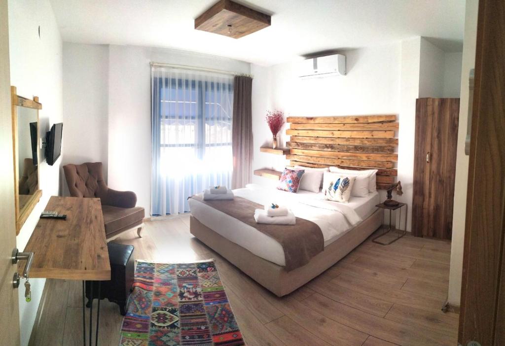 a bedroom with a large bed and a wooden headboard at Lavinia Otel in Cesme
