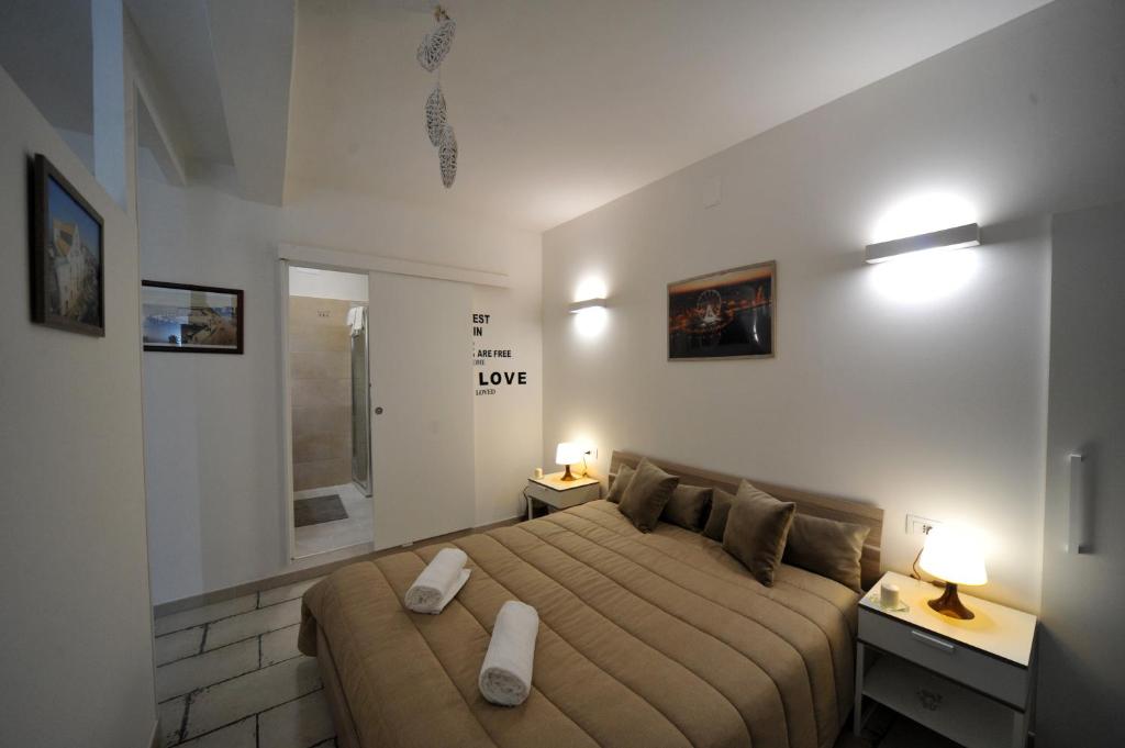 巴里的住宿－Pietra Bianca Appartment，一间卧室配有一张大床,上面有两个白色的物体