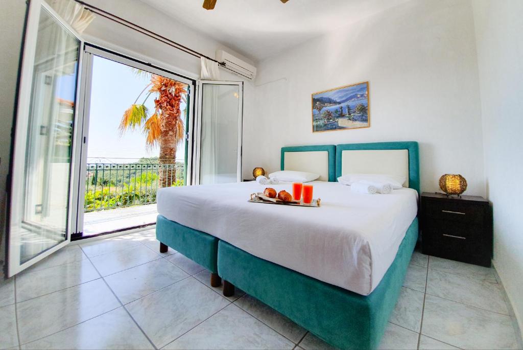 a bedroom with a bed and a large window at Giovanni Group Apartments in Syvota
