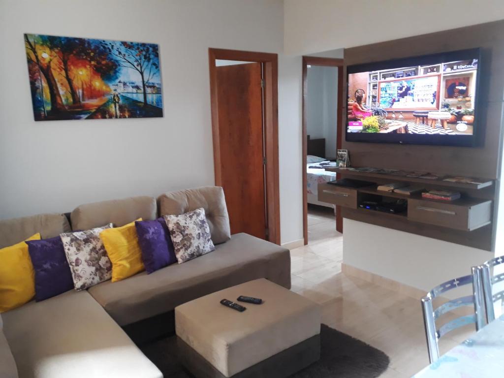 a living room with a couch and a flat screen tv at Condominio dos Lagos Capitolio 01 in Capitólio