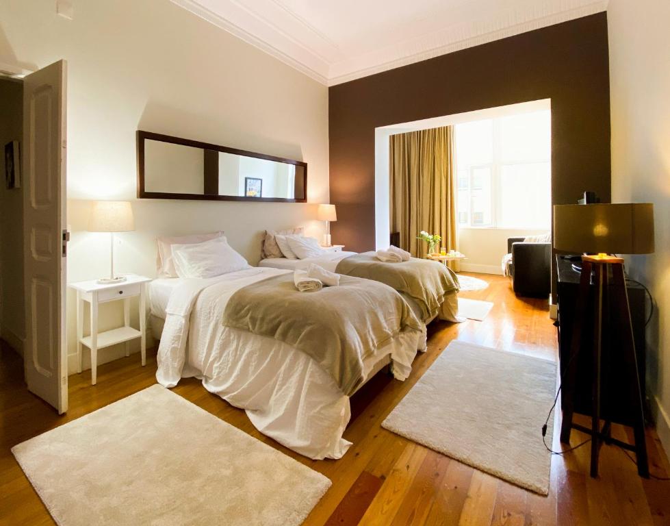 sypialnia z 2 łóżkami i lustrem na ścianie w obiekcie Guest House Bairro Azul w Lizbonie
