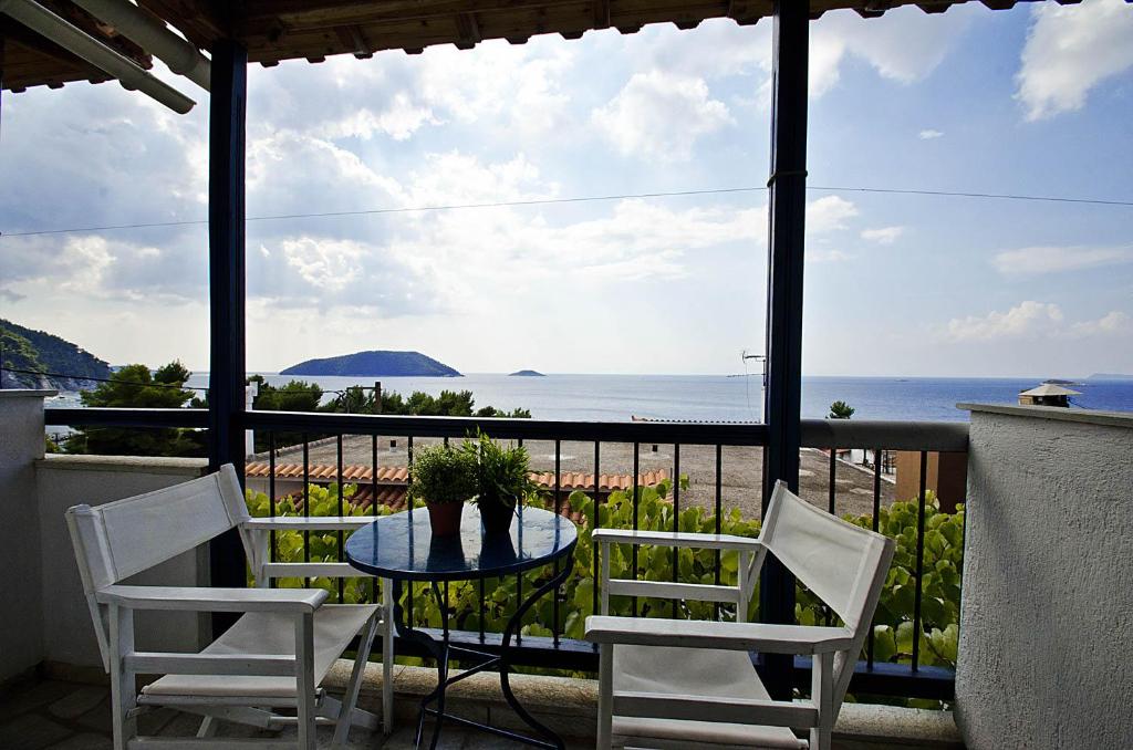 a table and chairs on a balcony with a view of the ocean at Violetta Apartments in Neo Klima