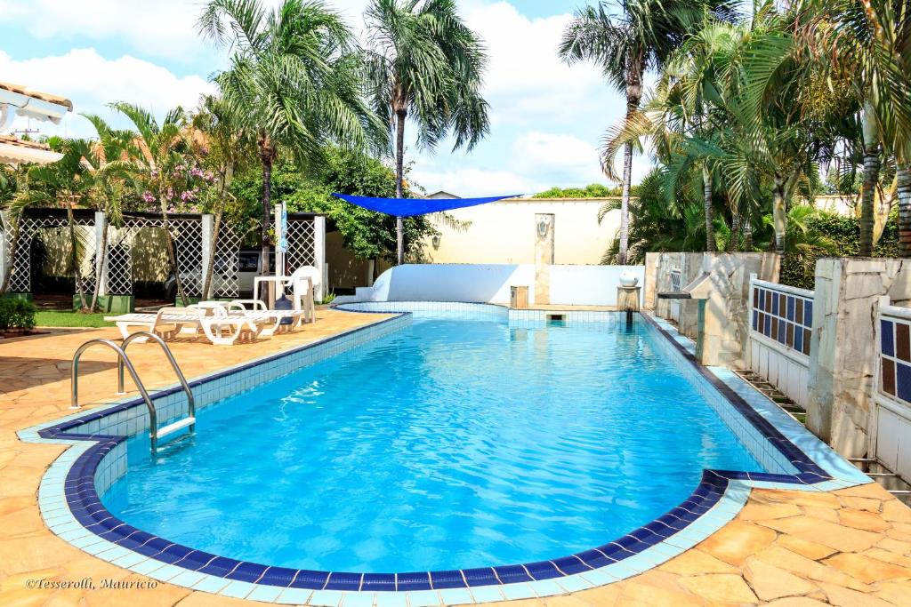 una piscina de agua azul en un patio en Recanto Serenissima en São Pedro