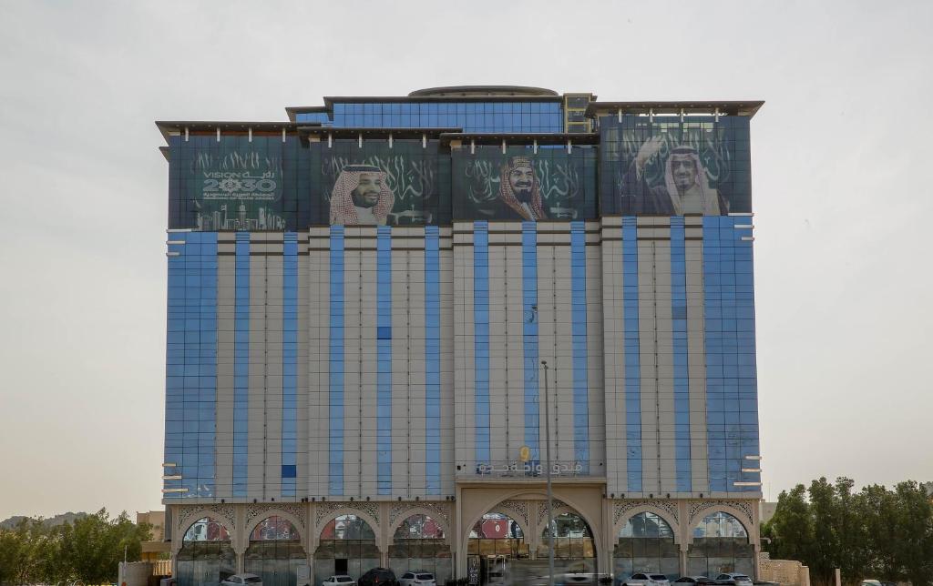 a tall building with billboards on the side of it at Jeddah Oasis Hotel in Jeddah
