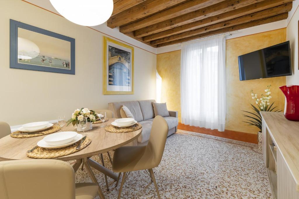 ein Wohnzimmer mit einem Tisch und einem Sofa in der Unterkunft Rialto - Sant'Aponal Prestige in Venedig