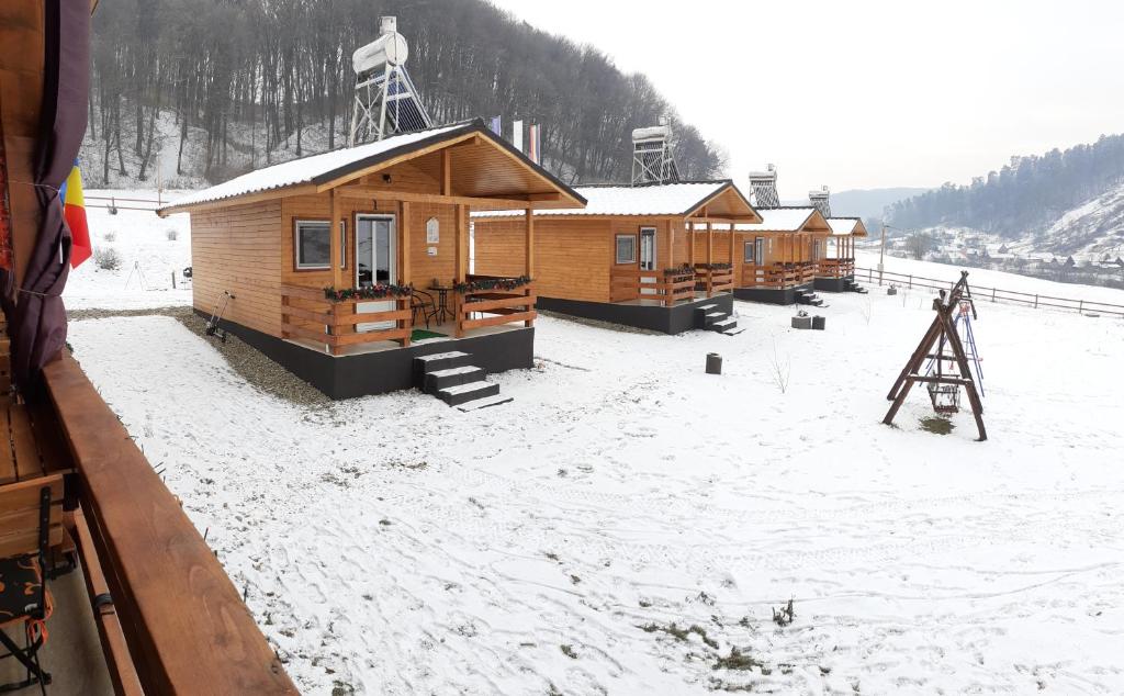 una fila de cabañas de madera en la nieve en Dara's Camping en Prod