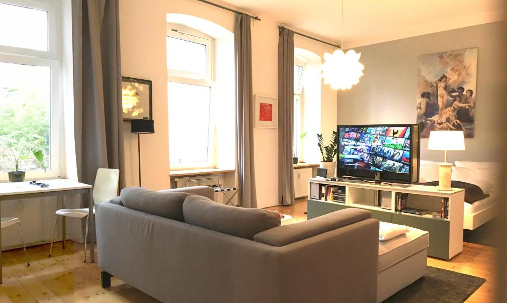 sala de estar con sofá y TV en Berlin Style Apartments - Schönholzer Straße, en Berlín