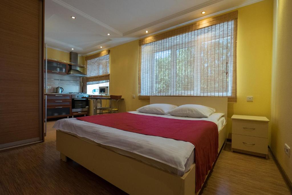 a bedroom with a large bed with a red blanket at ОК! Красноармейская, 101 in Tomsk