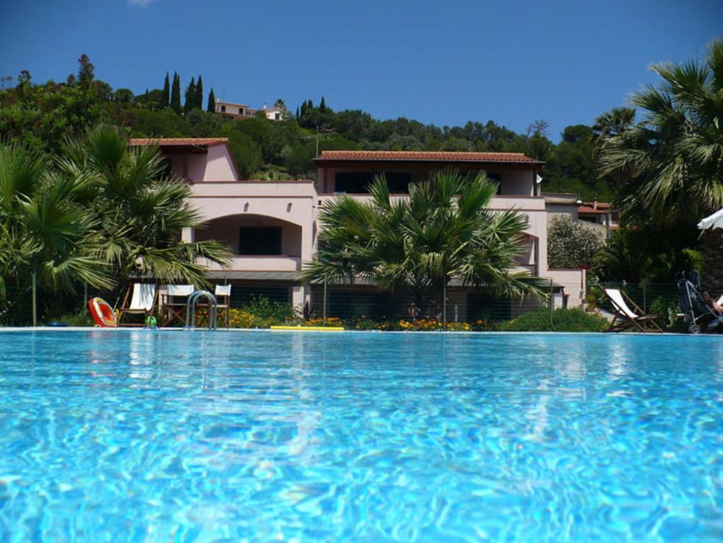 una gran piscina frente a una casa en Appartamenti Le Fornaci, en Marina di Campo