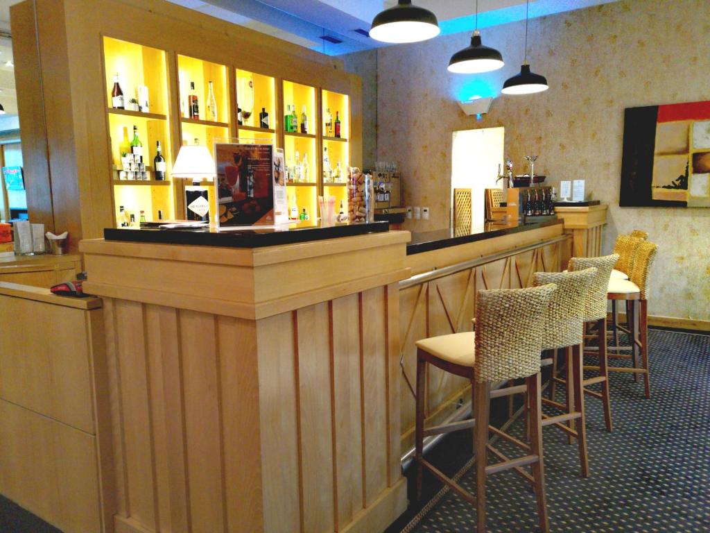 a bar in a restaurant with tables and chairs at Riviera Hotel in Carcavelos
