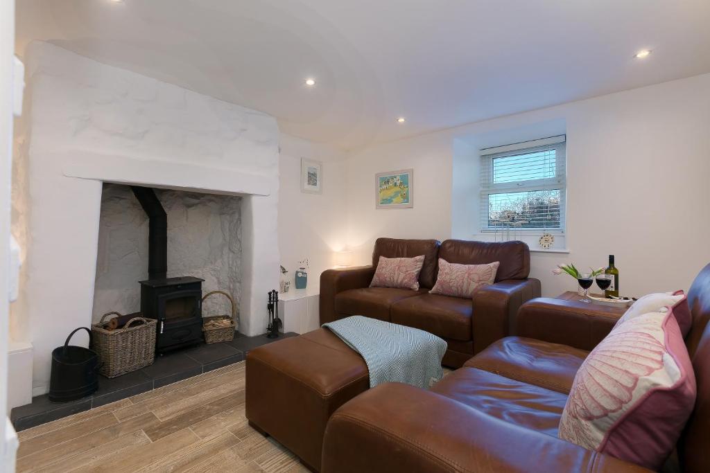 a living room with a couch and a fireplace at Whistler's Rest in St Ives