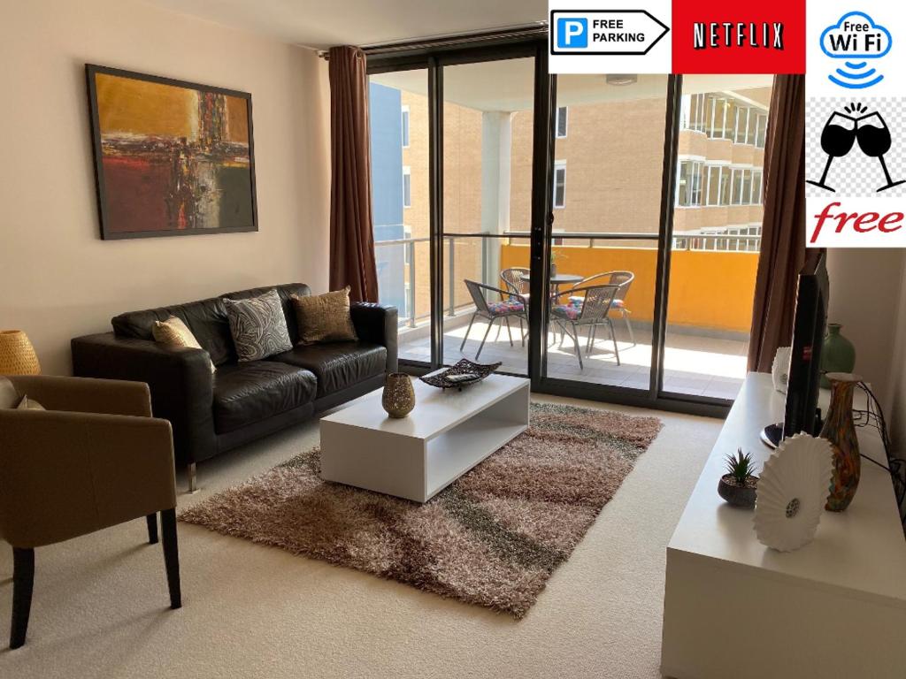 a living room with a couch and a table at ARENA RESORT STYLE EXEC FREE NETFLIX WIFI WINE in Perth