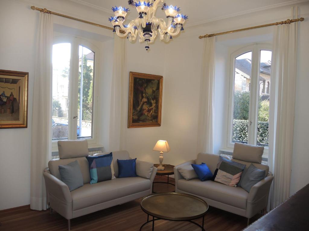 a living room with two couches and a chandelier at Casa Augusto in Bellinzona