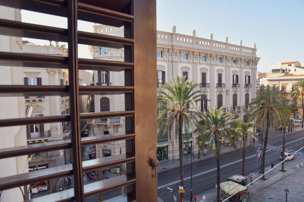 - une vue depuis la fenêtre d'une rue bordée de palmiers dans l'établissement Dimora San Domenico, à Palerme
