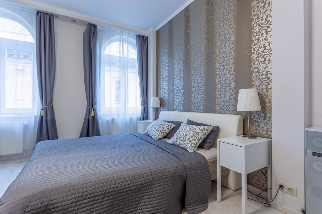 un dormitorio con una cama y una ventana en Goldcentral Apartment Grand Boulevard In The Heart Of The City, en Budapest