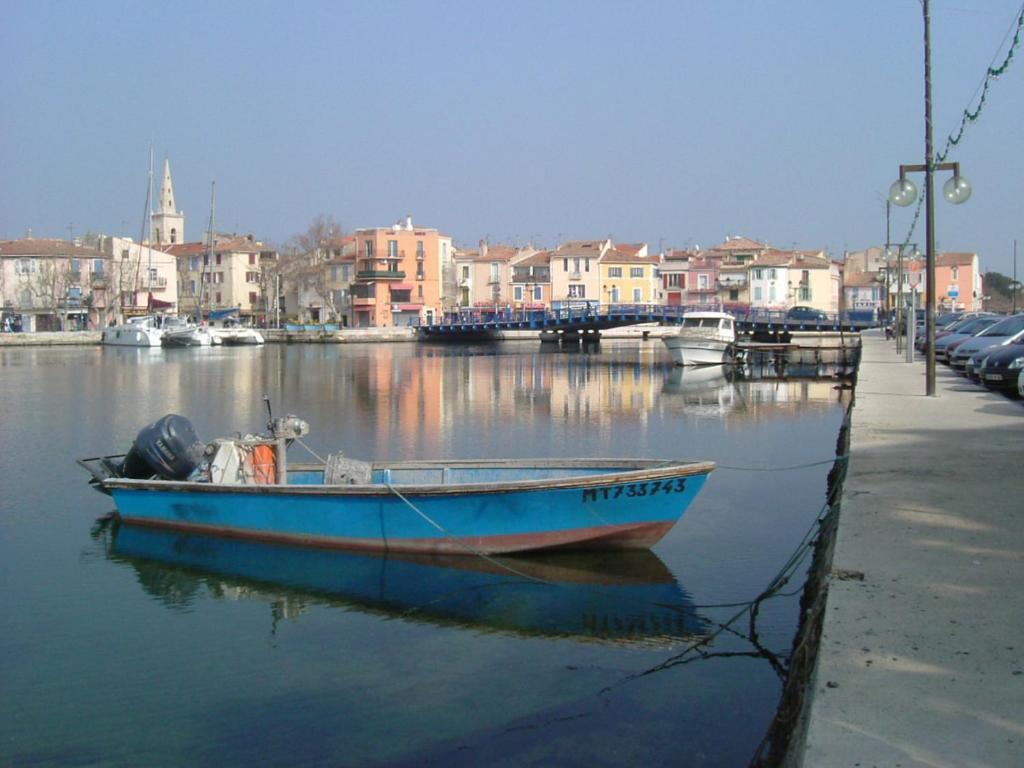 un bateau bleu est assis dans l'eau dans l'établissement Les Terrasses Vénitiennes, à Martigues