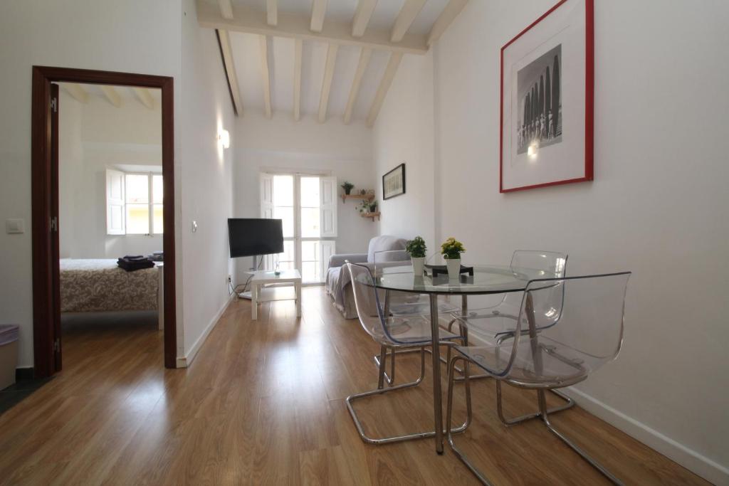 een woonkamer met een tafel en stoelen. bij Comfortable apartment with character in the old town in Palma de Mallorca